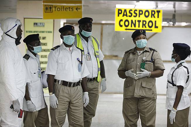 Nigeria health officials wait to screen passengers at the arrival hall of Murtala Muhammed International Airport in Lagos, Nigeria, Monday, Aug. 4, 2014. Nigerian authorities on Monday confirmed a second case of Ebola in Africa's most populous country, an alarming setback as officials across the region battle to stop the spread of a disease that has killed more than 700 people.