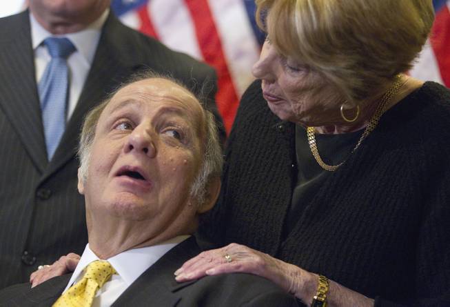 This March 30, 2011, file photo shows former White House press secretary James Brady, left, who was left paralyzed in the Reagan assassination attempt, looking at his wife, Sarah Brady, during a news conference on Capitol Hill in Washington marking the 30th anniversary of the shooting. A Brady family spokeswoman says Brady has died at 73.