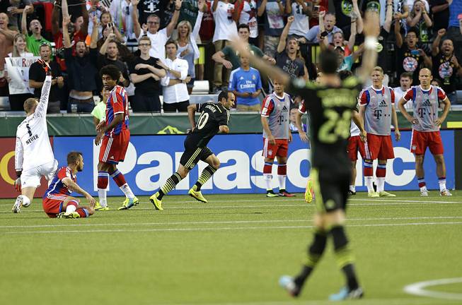 Los Angeles Galaxy forward Landon Donovan, center rear, celebrates after he scored the go-ahead goal on Bayern Munich goalkeeper Manuel Neuer, left, in the second half of the MLS All-Star soccer game, Wednesday, Aug. 6, 2014, in Portland, Ore. The MLS All-Stars won 2-1. 