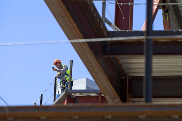 A construction worker makes a call from a building at the northeast corner of Sahara Avenue and Las Vegas Boulevard South Thursday, August 7, 2014. A Walgreens will occupy about half of the first floor. Wilger Enterprises is the general contractor on the project.