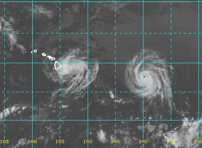 This image provided by NOAA taken at 2 a.m. EDT Friday Aug. 8, 2014 shows Hurricane Iselle approaching the Island of Hawaii, left as Hurricane Julio with a well defined eye follows. 