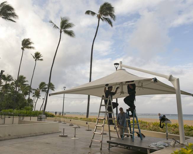 In preparation for heavy winds, workers at the Hale Koa Hotel remove an awning from an outdoor stage in Honolulu on Friday, Aug, 8, 2014. Iselle came ashore early Friday as a weakened tropical storm, while Hurricane Julio, close behind it, strengthened and is forecasted to pass north of the islands. Iselle is the first tropical storm to hit the state in 22 years. 