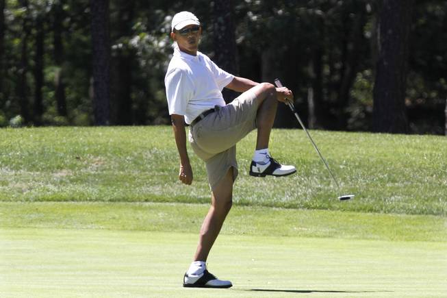 This Aug. 11, 2013, file photo shows President Barack Obama reacting as he misses a shot while golfing on the first hole at Farm Neck Golf Club in Oak Bluffs, Mass., on the island of Martha's Vineyard.