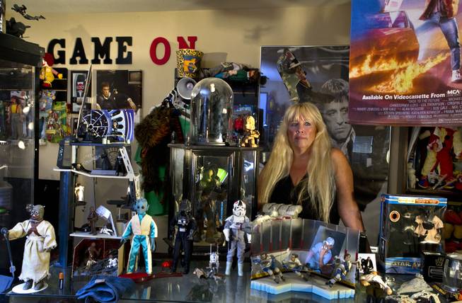 Zita Doyle is surrounded by her husband Cesar Flores' extensive toy collection in their home Friday, Aug. 8, 2014. He was recently killed while riding his bicycle by a driver who has been accused of DUI.