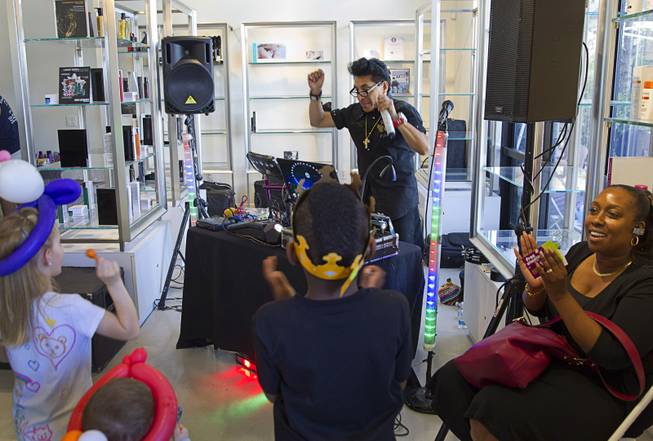 DJ Miguel plays the "Chicken Dance" during a special back-to-school event for foster children at Square Salon, 1225 South Fort Apache Blvd., during a Sunday, August 10, 2014. The event was sponsored by the CASA Foundation, a local non-profit organization, in partnership with Square Salon and other organizations.