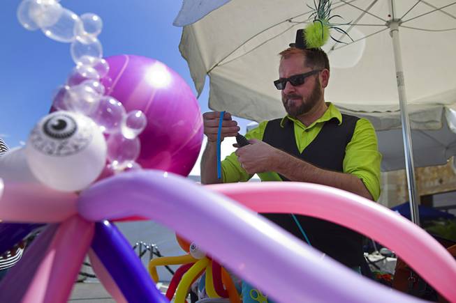Entertainment specialist Kris Cope works on a ballon hat during a special back-to-school event for foster children at Square Salon, 1225 South Fort Apache Blvd., during a Sunday, August 10, 2014. The event was sponsored by the CASA Foundation, a local non-profit organization, in partnership with Square Salon and other organizations.