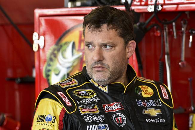 In this Friday, Aug. 8, 2014 photograph, Tony Stewart stands in the garage area after a practice session for Sunday's NASCAR Sprint Cup Series auto race at Watkins Glen International, in Watkins Glen, N.Y.