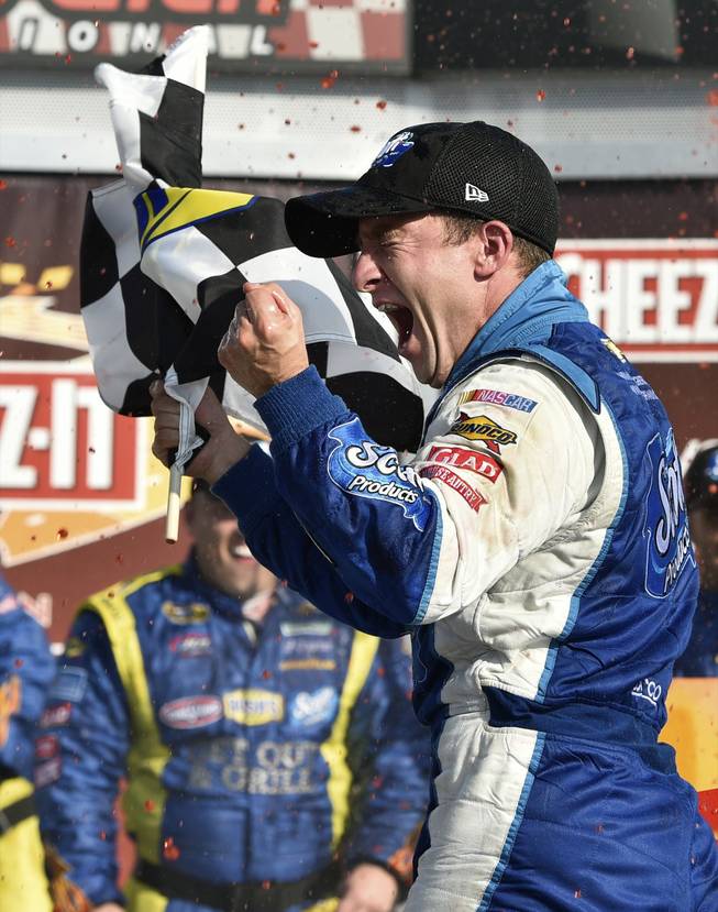 AJ Allmendinger waves the checkered flag as he celebrates in Victory Lane after winning a NASCAR Sprint Cup Series auto race at Watkins Glen International, Sunday, Aug. 10, 2014, in Watkins Glen, N.Y.