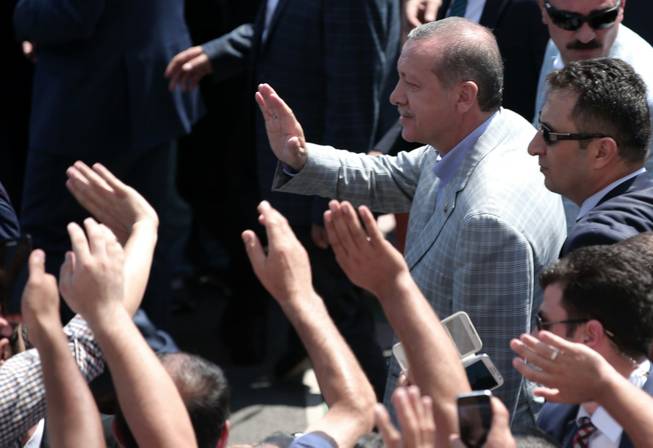 Turkish Prime Minister Recep Tayyip Erdogan, who won the country's first ever direct presidential election in the first round Sunday, according to an unofficial vote count, salutes cheering supporters at a polling station in Istanbul, Turkey, Sunday, Aug. 10, 2014. Turks were voting in their first direct presidential election Sunday - a watershed event in Turkey’s 91-year history, where the president was previously elected by Parliament.