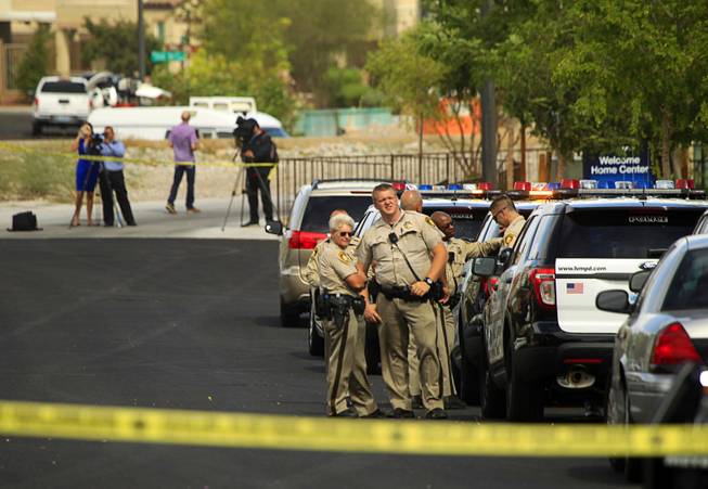 Metro Police are shown in a residential area near Fort Apache and Farm roads after an officer-involved shooting Monday, Aug. 11, 2014. Police said a suspect was shot after officers responded about 1 p.m. to a disturbance call.