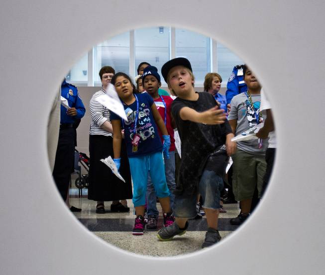Matthew Moore, 10, with team TSA tosses his airplane towards an open hole in an accuracy competition during Paper Plane Palooza competition at McCarran International Airport on Tuesday, August 12, 2014.
