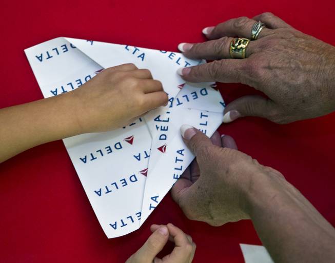 One of many paper airplanes is folded during the Paper Plane Palooza at McCarran International Airport on Tuesday, August 12, 2014.