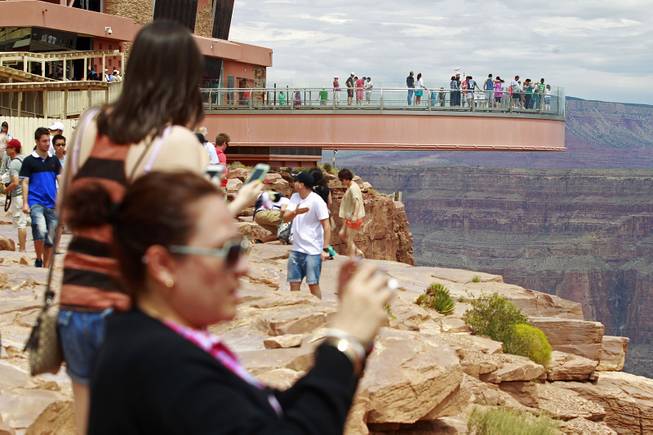 Visitors take photos at Grand Canyon West Tuesday, Aug. 12, 2014.