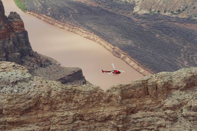 A helicopter flies through the Grand Canyon at Grand Canyon West Tuesday, Aug. 12, 2014.