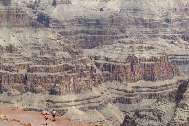 Tourists walk on a trail at Guano Point at Grand Canyon West Tuesday, Aug. 12, 2014.