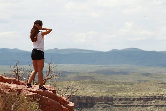 A tourist takes in the view at Grand Canyon West Tuesday, Aug. 12, 2014.