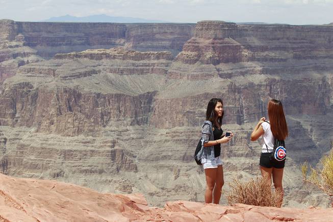 Tourists takes in the view at Grand Canyon West Tuesday, Aug. 12, 2014.