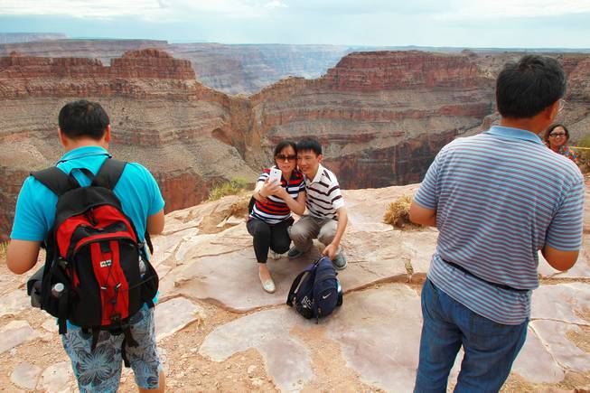Chinese tourists take photos at Grand Canyon West Tuesday, Aug. 12, 2014.
