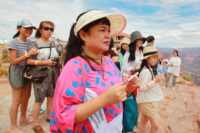 Chinese tourists take in the view at Grand Canyon West Tuesday, Aug. 12, 2014.