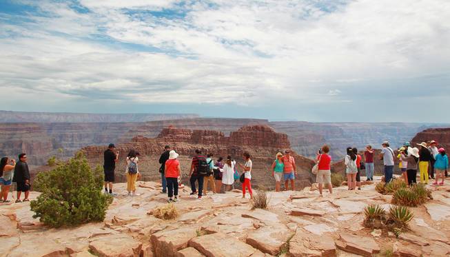 Tourists take photos at Grand Canyon West Tuesday, Aug. 12, 2014.