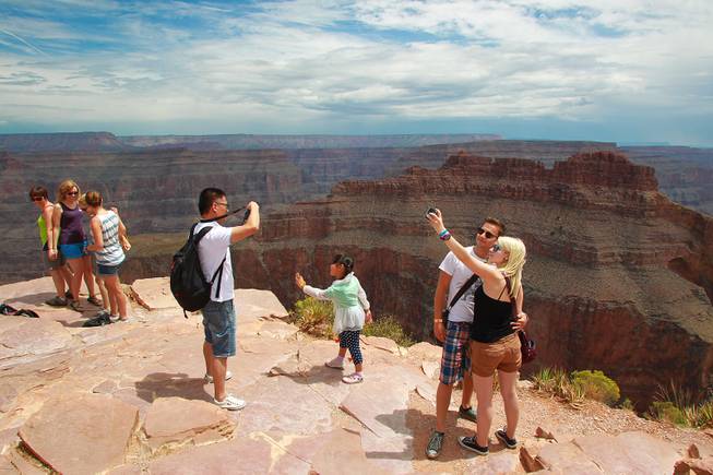 Tourists take photos at Grand Canyon West Tuesday, Aug. 12, 2014.