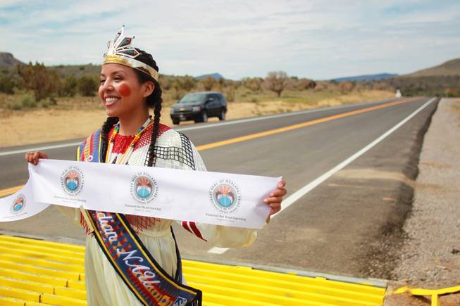 Jewel Diamond Honga holds one end of a ribbon during the official opening of the newly paved section of Diamond Bar Road leading to Grand Canyon West Tuesday, Tuesday, Aug. 12, 2014.