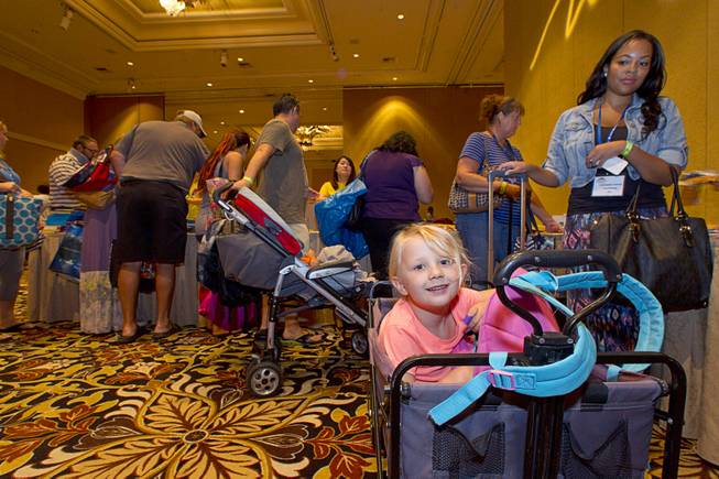 Eleanor Stender, 5, sits in a wagon as her mother, an art teacher at Fremont Middle School, gathers school supplies during MGM Resorts annual Educator Appreciation Day at the Mirage Thursday Aug. 14, 2014. In addition to school supplies provided by MGM Resort employees, a variety of agencies participated in the days activities to introduce educators to teaching resources available in the community.
