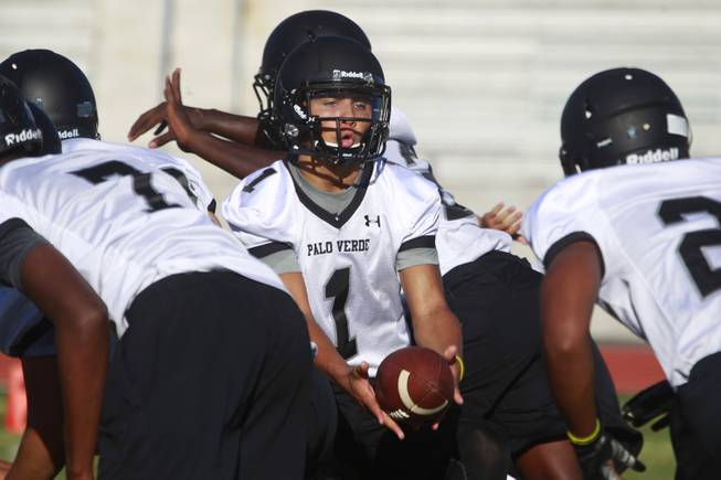 Palo Verde quarterback Graeson Vereen hands off the ball during their first official practice Thursday, Aug. 14, 2014.