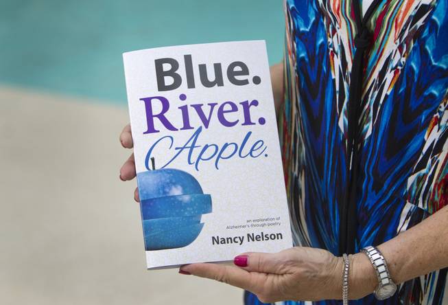Nancy Nelson, 70, holds her book of poetry titled "Blue. River. Apple." at her home in Summerlin on Tuesday, Aug. 12, 2014. After being diagnosed with early-onset Alzheimer's disease last year, Nelson began waking up at 3 a.m. and would write poetry, she said. 