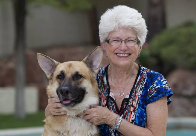 Nancy Nelson, 70, poses with Levi, a 2-year-old German shepherd, at her home in Summerlin on Tuesday, Aug. 12, 2014. After being diagnosed with early-onset Alzheimer's disease last year, Nelson began waking up at 3 a.m. and would write poetry, she said. Her book of poetry titled "Blue. River. Apple." was recently published. 