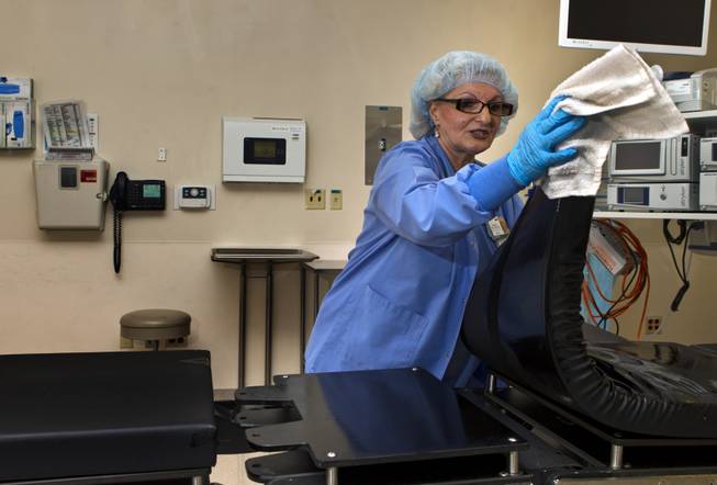 Zana Oprescu cleans an operating room as an environmental services aide at Sunrise Hospital on Tuesday, August 12, 2014.
