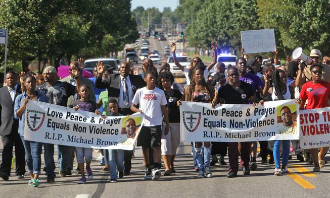 A march organized by area ministers makes its way down W. Florissant in Ferguson, Mo. on Wednesday, Aug. 13, 2014. On Saturday, Aug. 9, 2014, a white police officer fatally shot Michael Brown, an unarmed black teenager, in the St. Louis suburb.