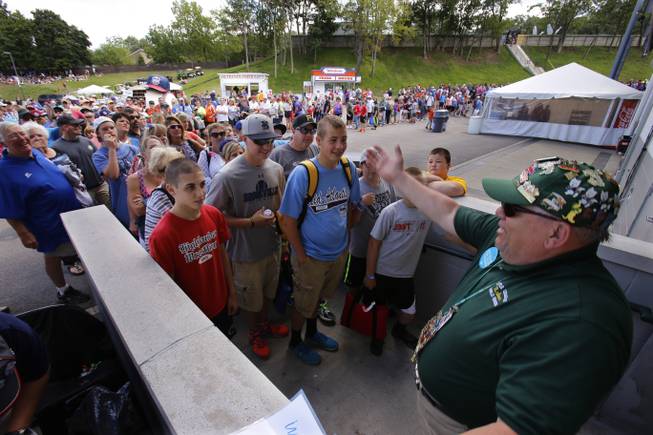 Lamade Stadium usher Dave Stoker, right, opens the gates for a crowd gathered to see a baseball game between Chicago and Las Vegas in United States pool play at the Little League World Series tournament in South Williamsport, Pa., Sunday, Aug. 17, 2014. 
