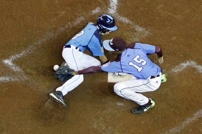 Las Vegas' Dallan Cave (8) scores on a wild pitch by Philadelphia pitcher Kai Cummings (15) in the sixth inning of a U.S. semifinal baseball game at the Little League World Series in South Williamsport, Pa., on Wednesday, Aug. 20, 2014. Las Vegas won 8-1.