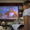 In this Wednesday, Aug. 20, 2014, photo, a waitress works during the pre-launch rehearsal at the new restaurant Nazdarovie, where the reproduction of a Soviet propaganda poster hangs over the bar area in Havana, Cuba. The new retro-Soviet restaurant serves minty mojitos, but they come mixed with vodka instead of the traditional white rum. 