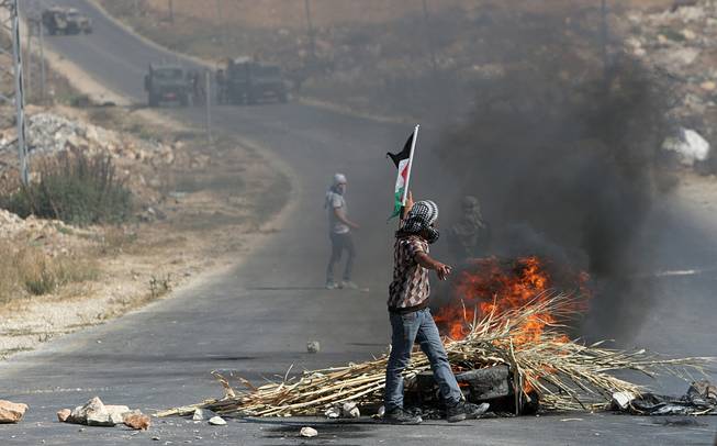 Palestinian protesters face Israeli soldiers during clashes, following a protest against the Israeli military action in Gaza, in the West Bank city of Nablus on Friday, Aug. 22, 2014. 