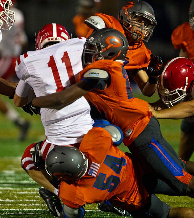 Bishop Gorman defenders team up to sack Brophy Prep QB Cade Knox on their way to a 44-0 win on Friday, August 22, 2014.