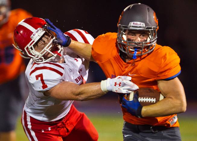 Bishop Gorman RB Jonathan Shumaker (#33) breaks free for another touchdown run with a stiff arm to the helmet of Brophy Prep LB Cole Wiegand (#7) on Friday, Aug. 22, 2014.