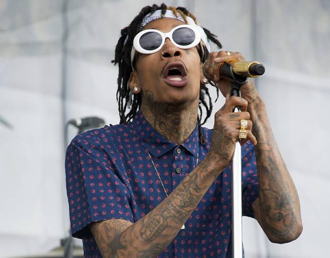 In this Saturday, July 5, 2014, file photo, U.S. rapper Wiz Khalifa performs on the main stage at Wireless Festival in Finsbury Park, north London. Police say a 38-year-old man has died after being shot multiple times backstage at Khalifa's concert at a popular Silicon Valley music venue.