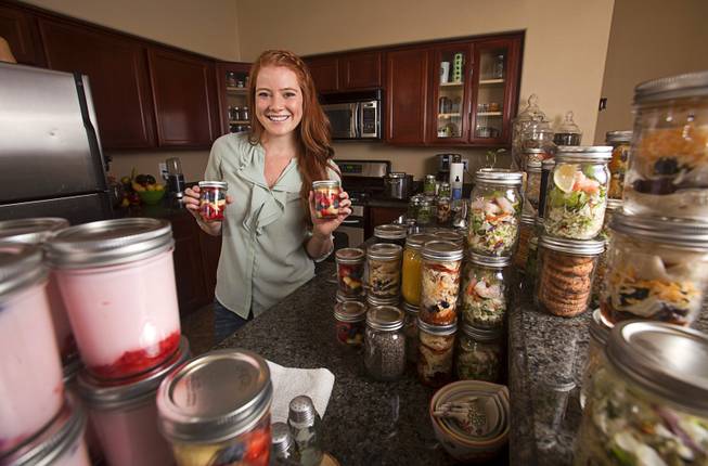 Chelsea Meggerson poses with Mason jars of "fruit cups" in her kitchen Sunday, Aug. 24, 2014. Meggerson, a UNLV student, provides a service where she provides families with fresh meals in Mason jars. She shares her recipes on her website theinspiregreen.com.