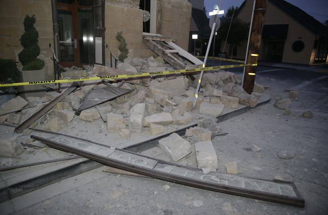 Rubble covers the sidewalk in front of the Vintners Collective multi-winery tasting room following an earthquake Sunday, Aug. 24, 2014, in Napa, Calif. A large earthquake rolled through California's northern Bay Area early Sunday, damaging some buildings, igniting fires, knocking out power to tens of thousands and sending residents running out of their homes in the darkness.