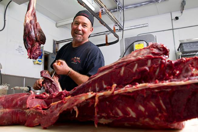 Chuck Frommer, owner of John Mull's Meats and Road Kill Grill, 3730 Thom Blvd., processes an antelope in the cutting room Monday, Aug. 25, 2014.