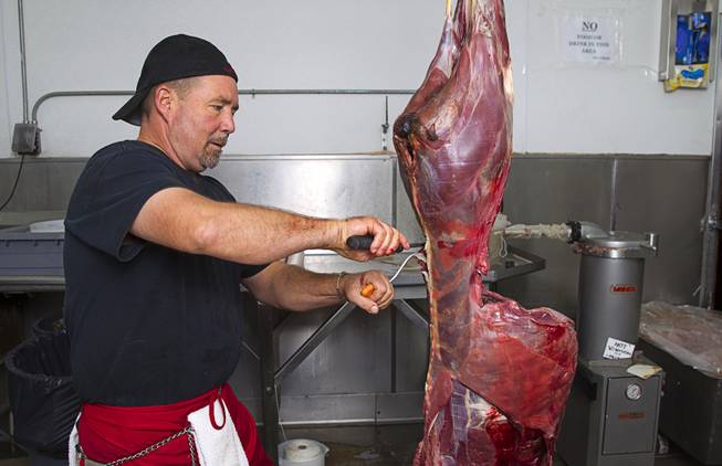 Chuck Frommer, owner of John Mull's Meats and Road Kill Grill, 3730 Thom Blvd., processes an antelope in the cutting room Monday, Aug. 25, 2014.