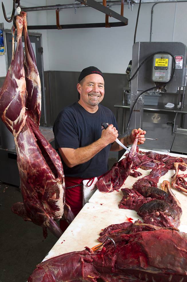 Chuck Frommer, owner of John Mull's Meats and Road Kill Grill, 3730 Thom Blvd., poses in the cutting room Monday, Aug. 25, 2014.