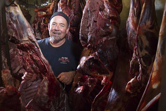 Chuck Frommer, owner of John Mull's Meats and Road Kill Grill, 3730 Thom Blvd., poses with skinned antelope in a meat cooler Monday, Aug. 25, 2014.