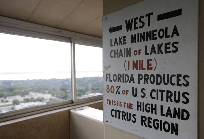 In this Friday, July 25, 2014 photo, a sign in the Florida Citrus Tower points west to Florida's citrus growing region, in Clermont, Fla. The observation tower was built in 1956 as a tourist attraction to view miles of citrus groves. Today Florida's $9 billion citrus industry is facing its biggest threat yet by a tiny invasive bug called the Asian Citrus Psyllid, which carries bacteria that are left behind when the psyllid feeds on a citrus tree's leaves. Eventually disease clogs the tree's vascular system and the tree slowly dies. 
