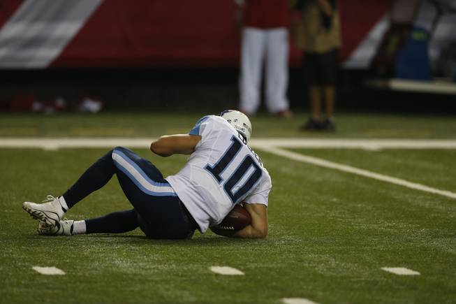 Tennessee Titans quarterback Jake Locker (10) lies on the field after a sack against the Atlanta Falcons during the first half of an NFL preseason football game, Saturday, Aug. 23, 2014, in Atlanta.