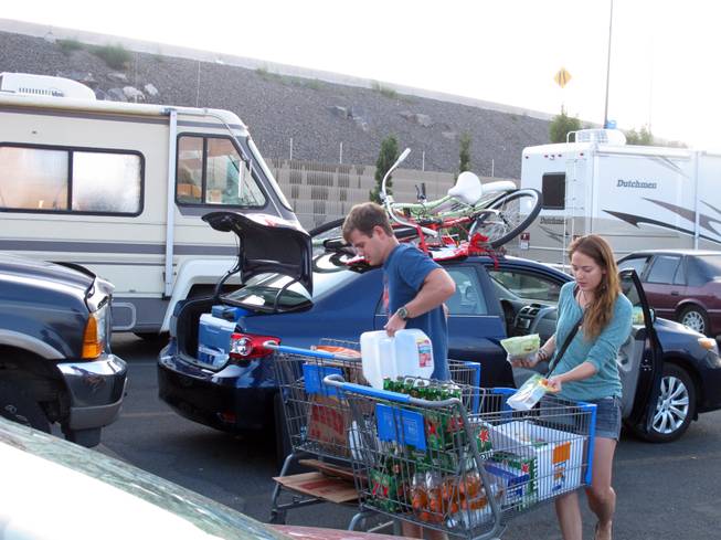 Jeff Difabrizio, left, and Jahliele Paquin of Yellowknife, Canada, load up provisions in the parking lot of a Wal-Mart, Monday, Aug. 25, 2014, in Reno on their first trek to Burning Man. More than 100 recreational vehicles camped out at the Wal-Mart and a Reno casino Monday night when a rare rain storm turned the Black Rock Desert, 90 miles north, into a muddy quagmire.