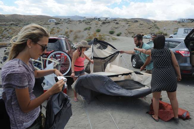 Tania Shoemaker reads the directions to her friends as they attempt to raise the second room of a two-room tent Monday at Pyramid Lake. Like hundreds of other Burners turned away at the playa due to storms, Shoemaker's group ended up at Pyramid Lake. 