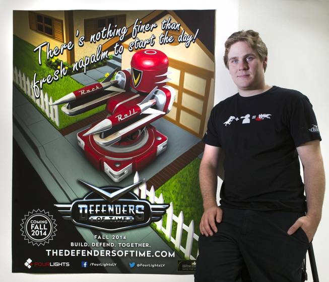 John Flury is CEO of Four Lights, a self-producing and self-publishing video game company on Wednesday, August 27, 2014. He is with a poster about their first release which is a multiplayer tower defense game "Defenders of Time," slated for official release in September. L.E. Baskow